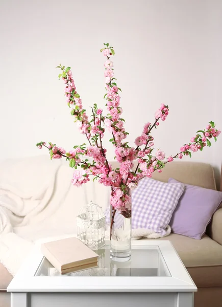 Spring bouquet in vase, on table, on home interior background