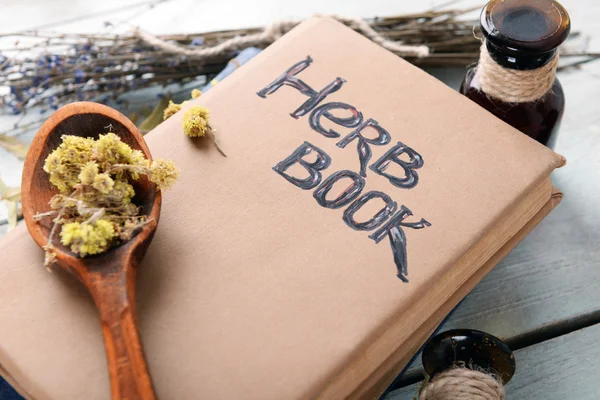 Different dried herbs and books on table close up