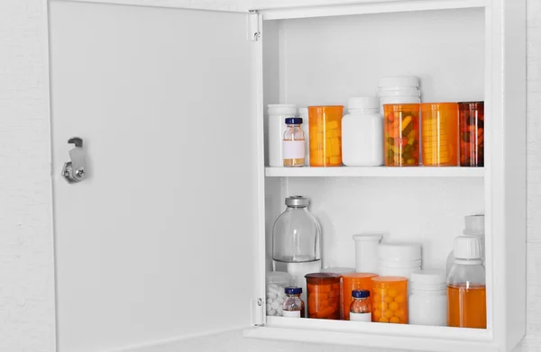Medicine chest with bottles of pills, closeup
