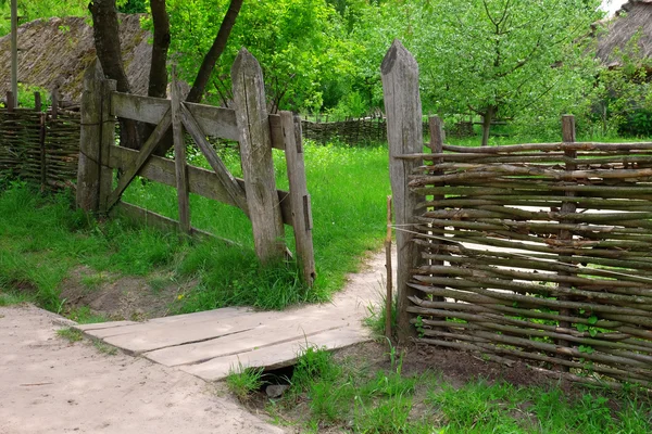 Wicker rustic fence in garden on grass background