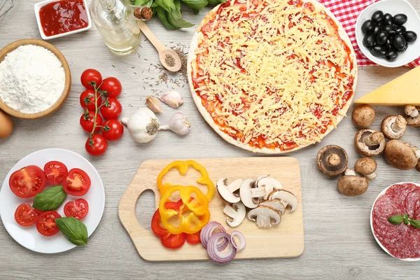 Food ingredients for pizza on table close up