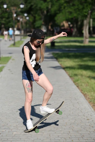 Beautiful tattooed girl with skateboard