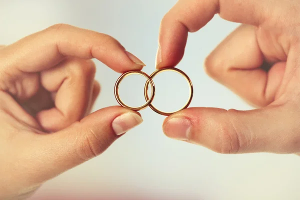 Woman and man holding wedding rings, close-up