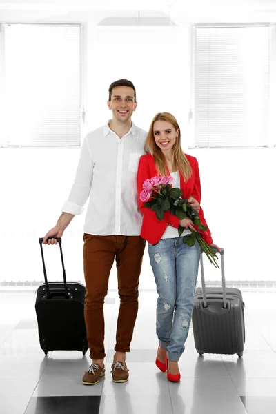 Portrait of young happy couple with baggage in airport