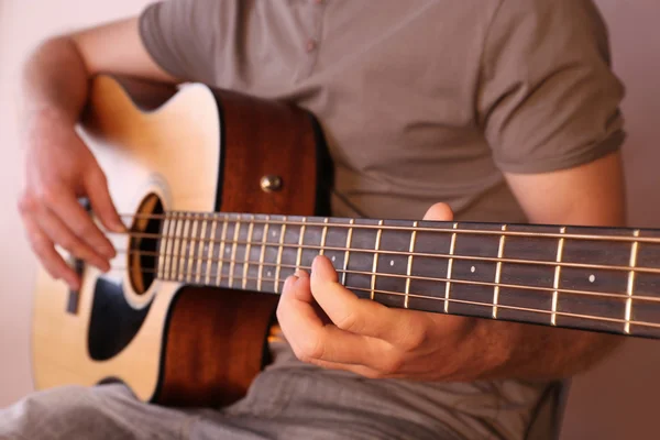 Young man playing on acoustic guitar