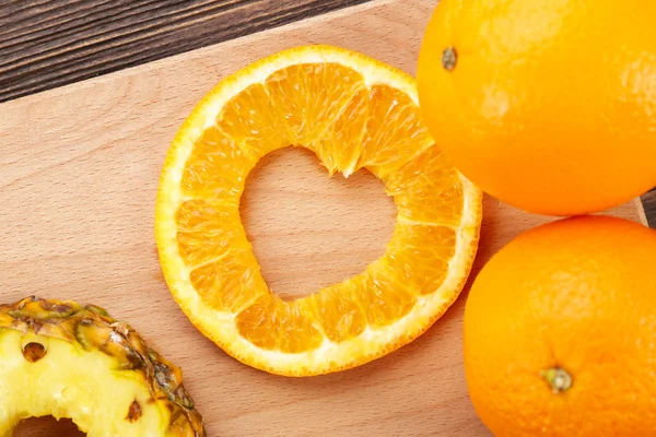 Orange slice with cut in shape of heart and fruits
