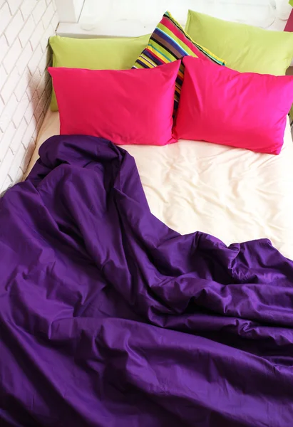 Comfortable bed with colorful pillows