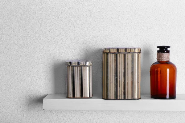 Decorative vases on wooden shelf