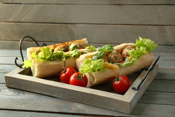 Homemade Spicy Meatball Sub Sandwich on tray, on wooden table background