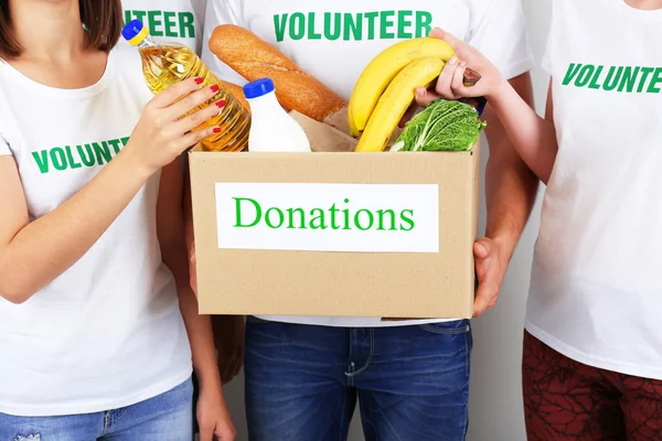 Volunteer holding donation box with food, closeup