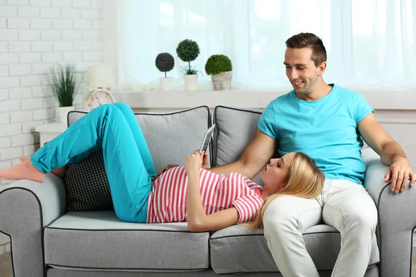 Pregnant woman with husband on sofa