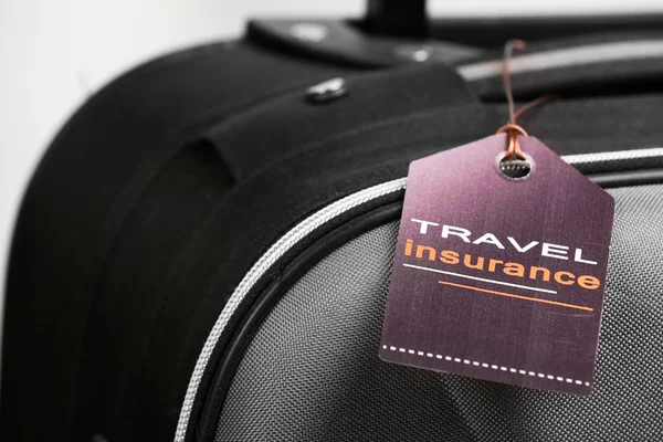 Suitcase with TRAVEL INSURANCE label