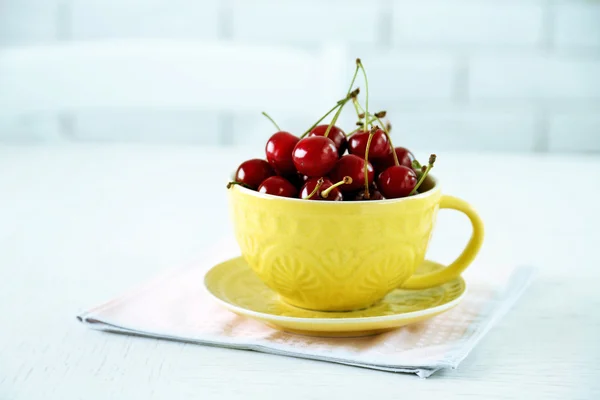 Cherries in mug on table