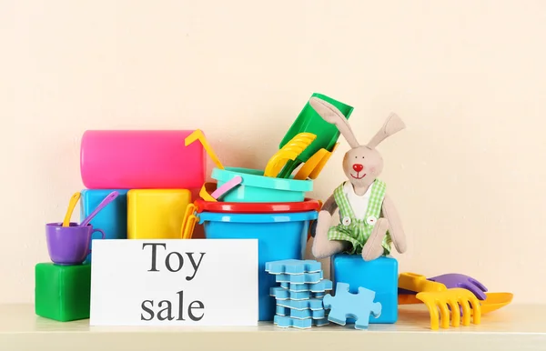 Toys for sale on shelf, on light wall background