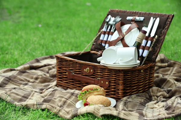 Wicker picnic basket, tasty sandwiches