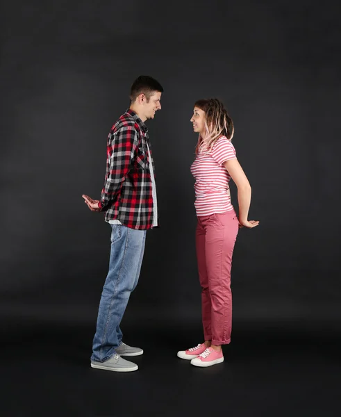 Emotional young couple on black background