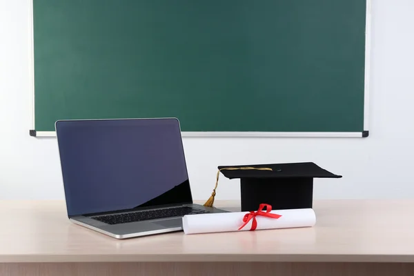 Notebook with diploma and master hat