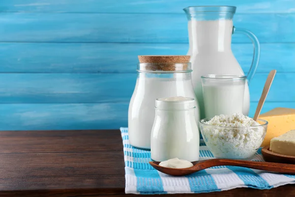 Dairy products on wooden table on blue  background