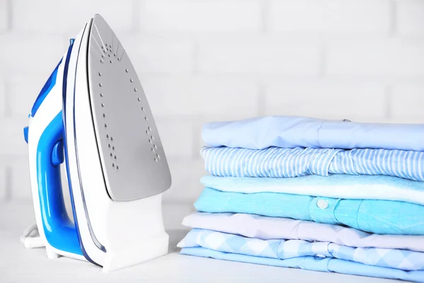 Electronic ironing and pile of clothes