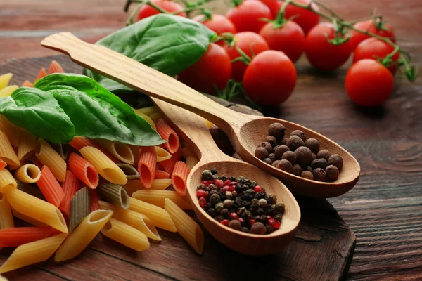 Pasta penne with tomatoes, cheese, spices and basil on rustic wooden  background