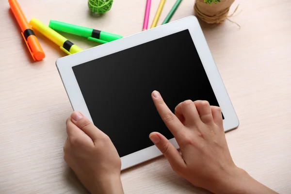 Woman using digital tablet on workplace close up