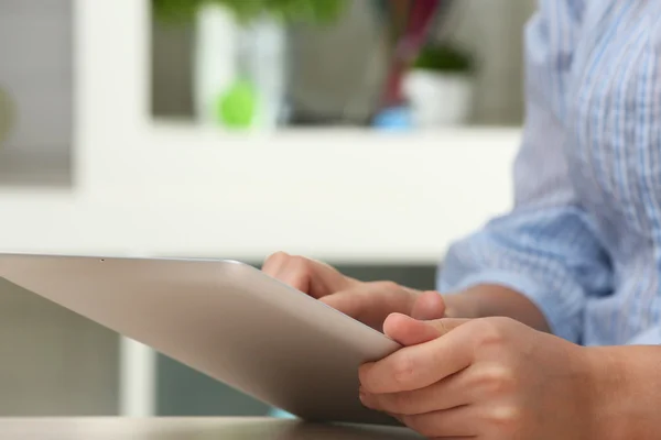 Woman using digital tablet on workplace close up