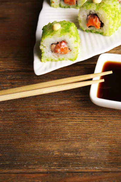 Rolls with sauce and sticks on wooden table close up