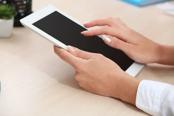 Woman using digital tablet on workplace close up