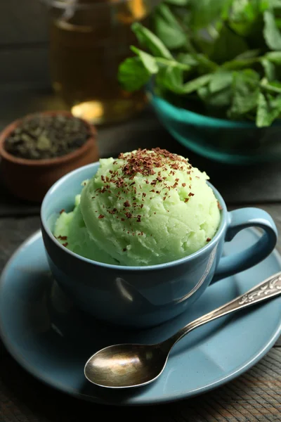 Homemade Green tea ice-cream in cup, on wooden background