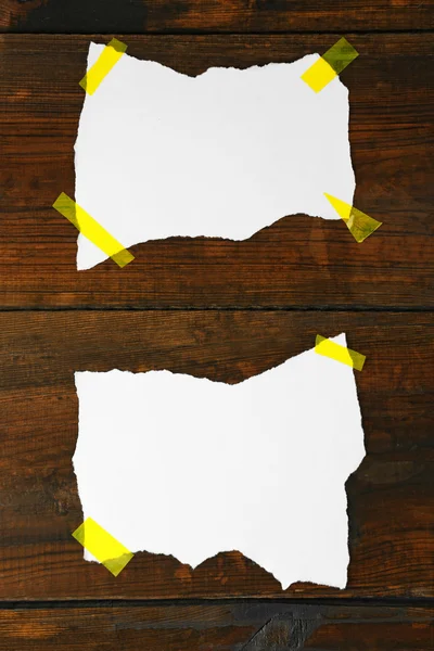 White pieces of paper attached on wooden background