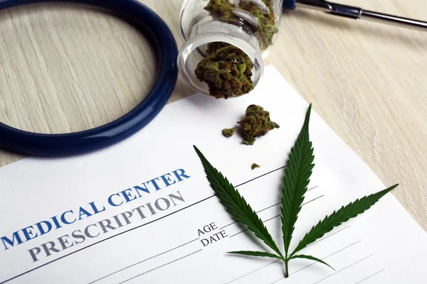Medical prescription with dry cannabis on table close up