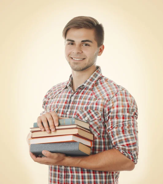 Young man with books on light background