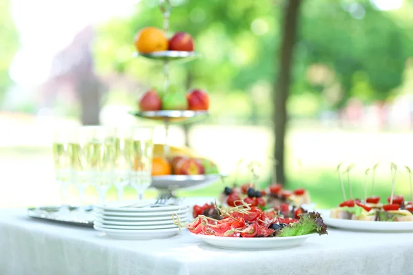 Snacks, fruits and drinks on table, outdoors. Garden party concept