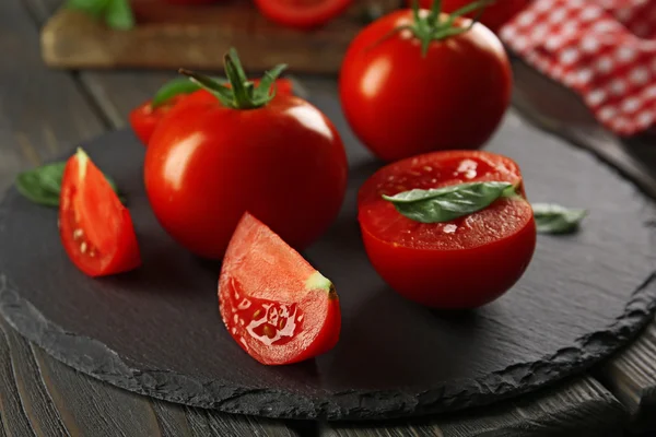 Red tomatoes and round cutting board