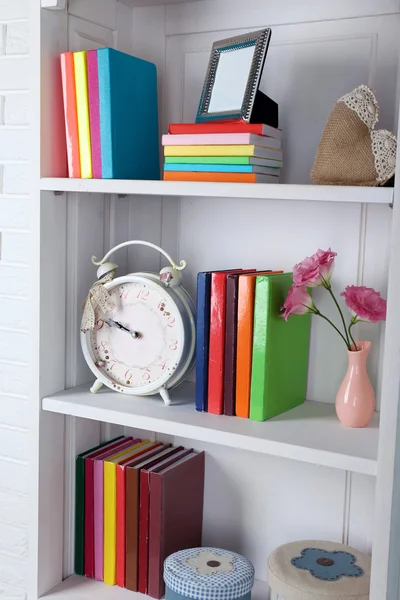 Books and decor on shelves in cupboard