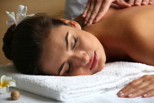 Young woman on massage table in beauty spa salon