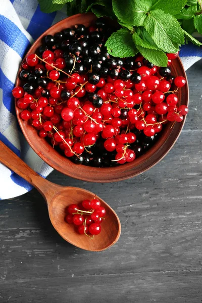 Forest berries in bowls on wooden background