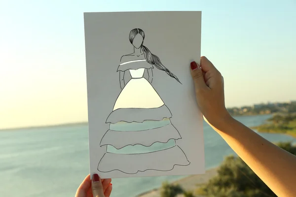 Woman in cutout dress on sheet of paper