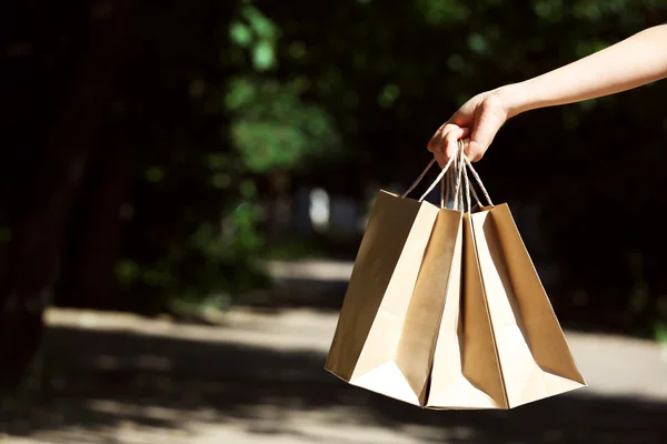 Female hand holding shopping bags outdoors