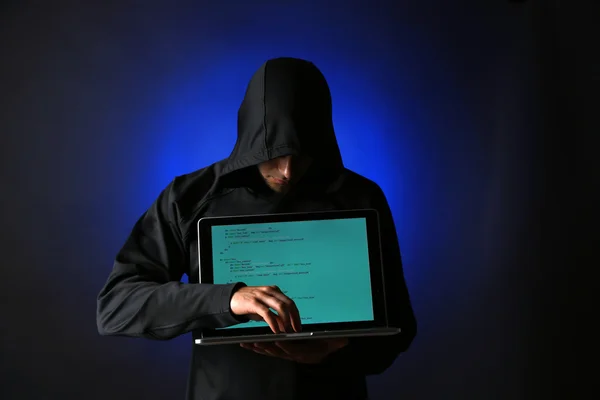 Hacker with computer and laptop on colorful dark background