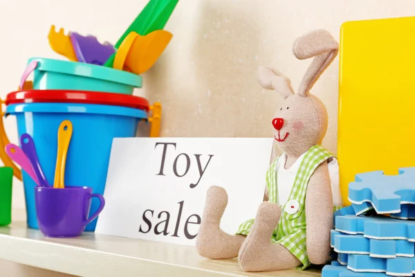 Toys for sale on shelf, on light wall background