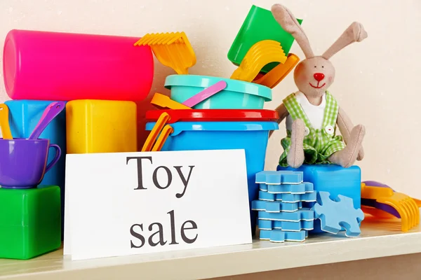 Toys for sale on shelf, on light wall background