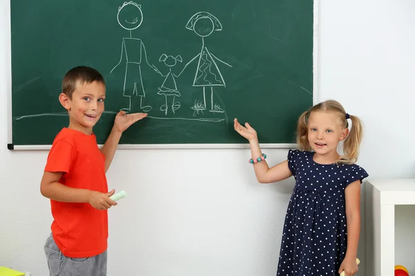 Children drawing on blackboard at school