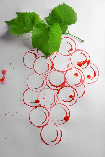 Grapes painted with red wine and cork isolated on white