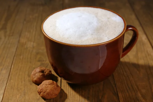 Cup of coffee and biscuits on wooden background