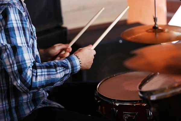 Hands of drummer with sticks and drums