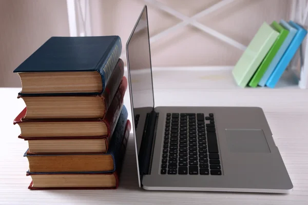 Stack of books with laptop