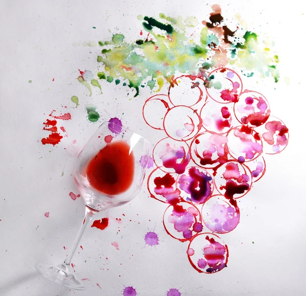 Grapes painted with wine and watercolors and wineglass of spilled wine on paper background