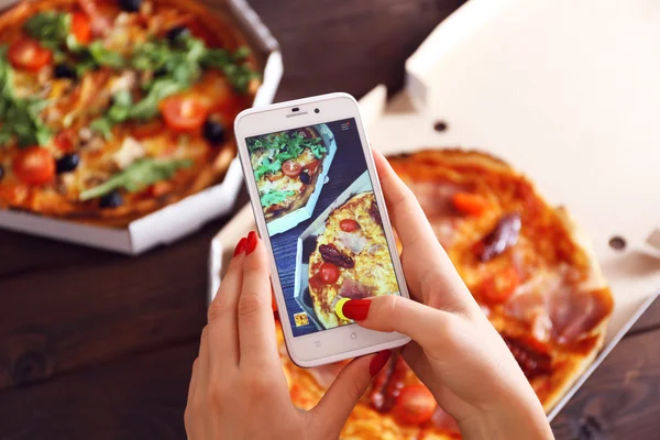 Woman taking a photo of pizza