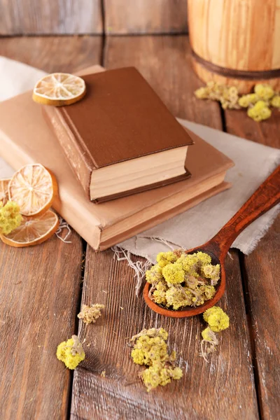 Old books with dry flowers and lemon